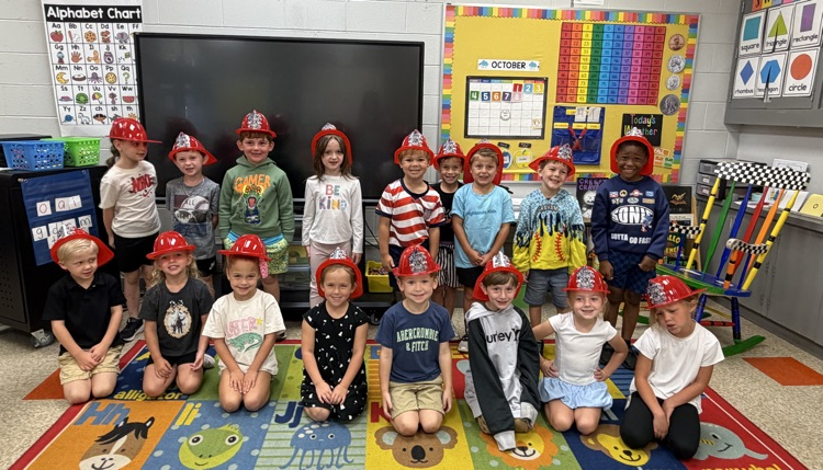 kindergarten students posing in their fire hats 