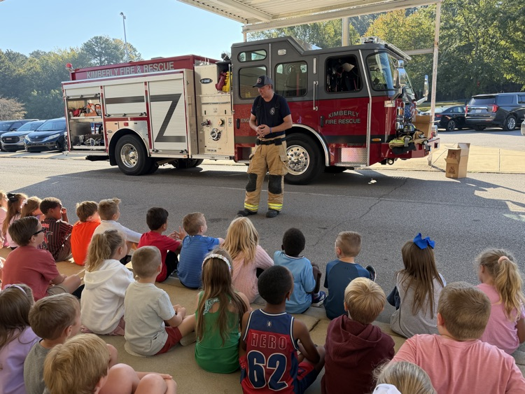 students listening to a fireman talk