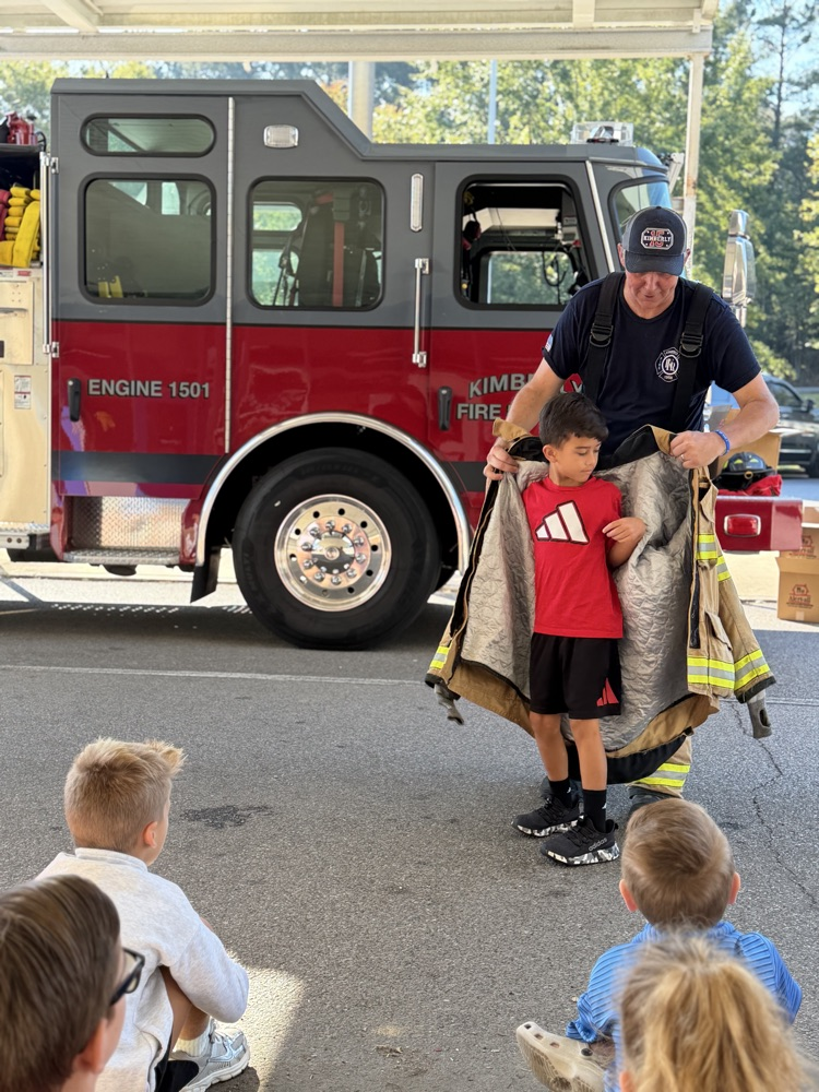 a student trying on the fireman jacket