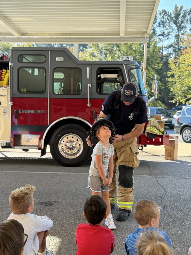 a student trying on the fireman hat