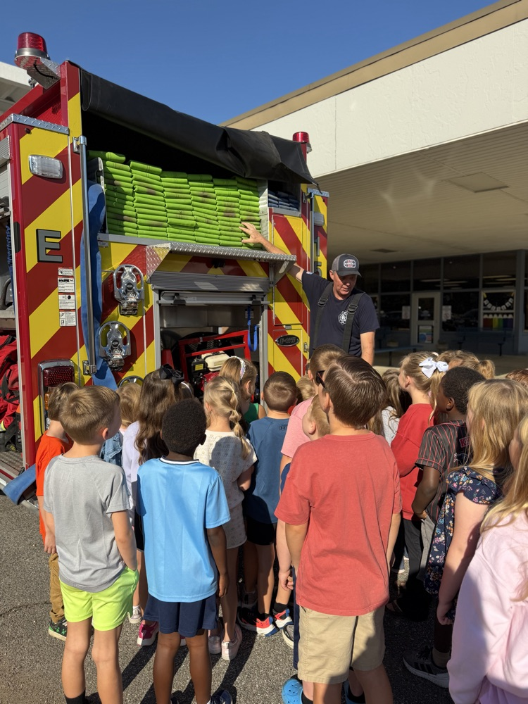 students looking at the fire hose in the truck