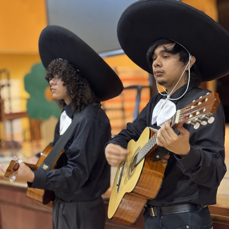 two mariachi band members playing stringed instruments
