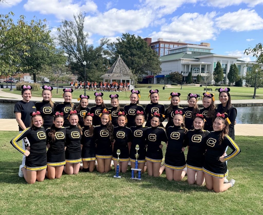 Cheerleaders outside in black and yellow uniforms and Disney ears