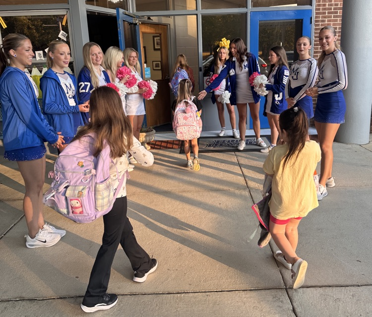 dancers and cheerleaders welcoming students into school 