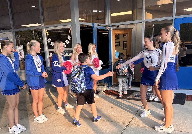 cheerleaders and dancers have having students as they enter the school