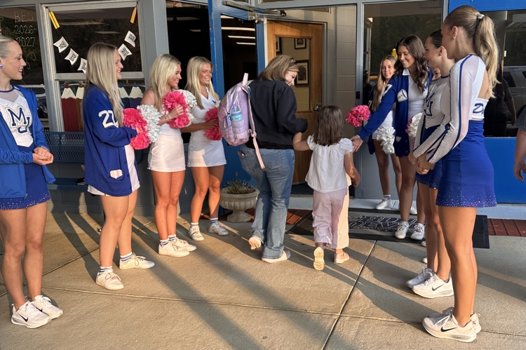 cheerleaders and dancers welcoming students into the school