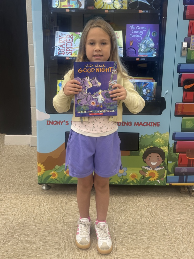 Young girl, smiling, and holding a book