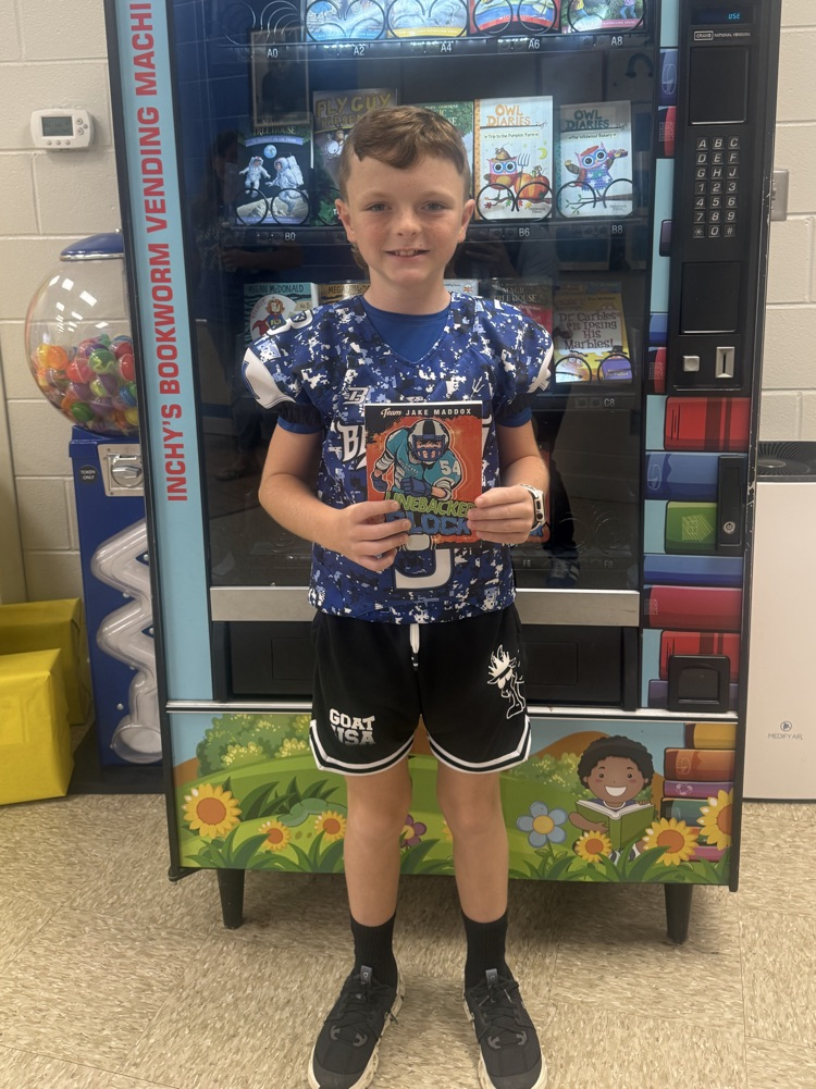 older student, smiling, and holding a book