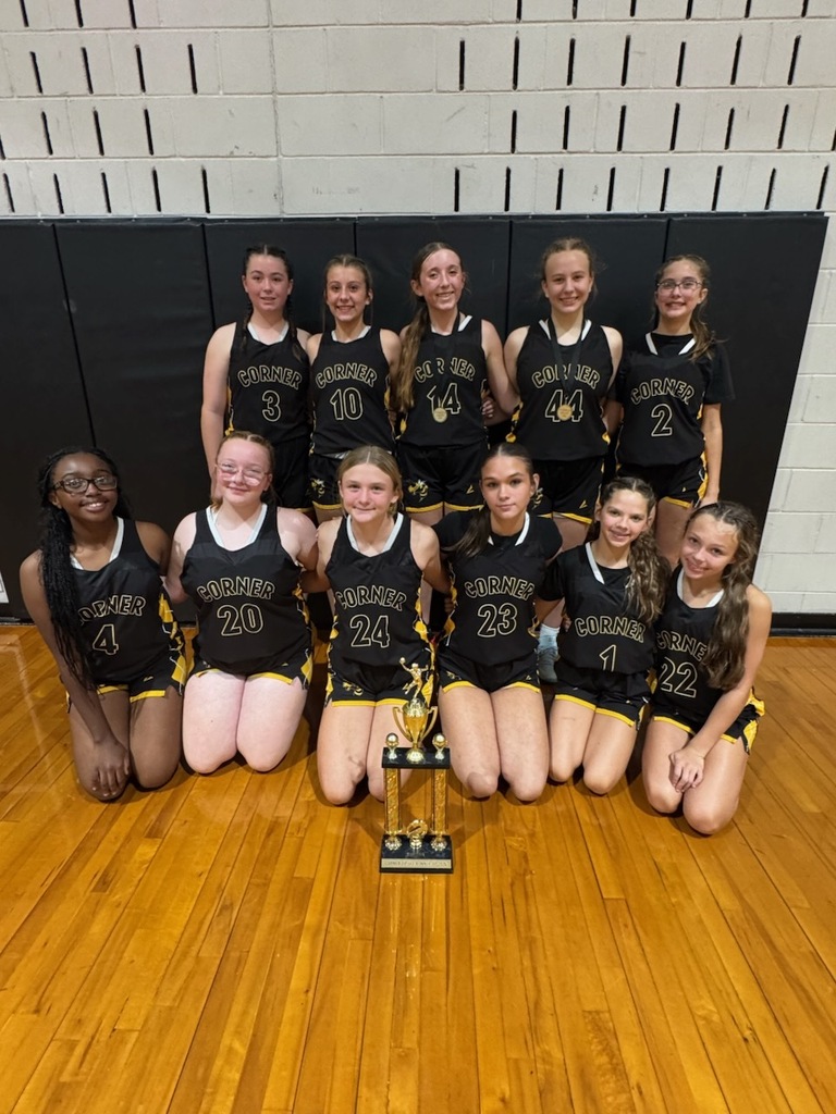 Girls Basketball players in a gym with a trophy