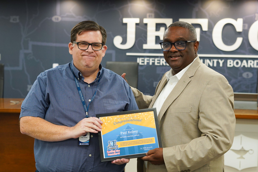 Superintendent Dr. Walter Gonsoulin poses for a photo with Paul Kelsey in the JEFCOED Board Room. They hold Paul's JEFCOED Strong Award.