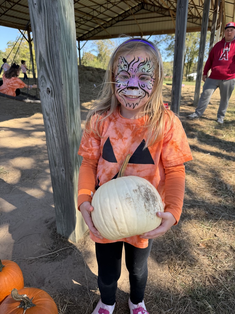 Girl holding pumpkin at pumpkin patch