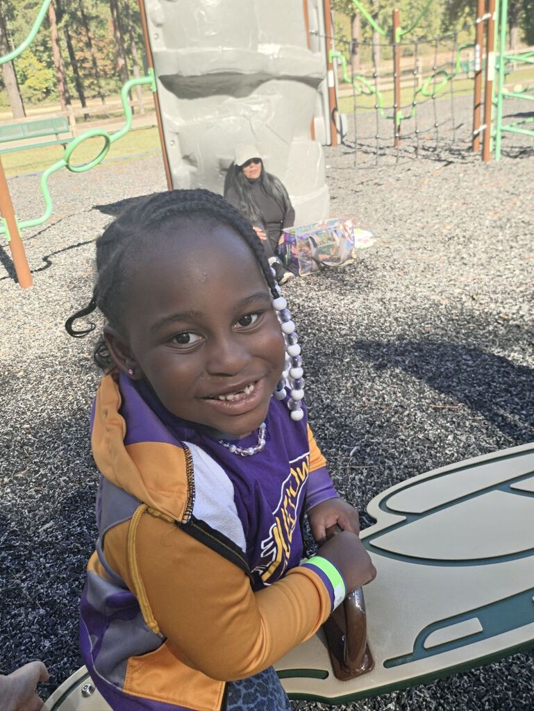 a student riding on a seesaw at the park