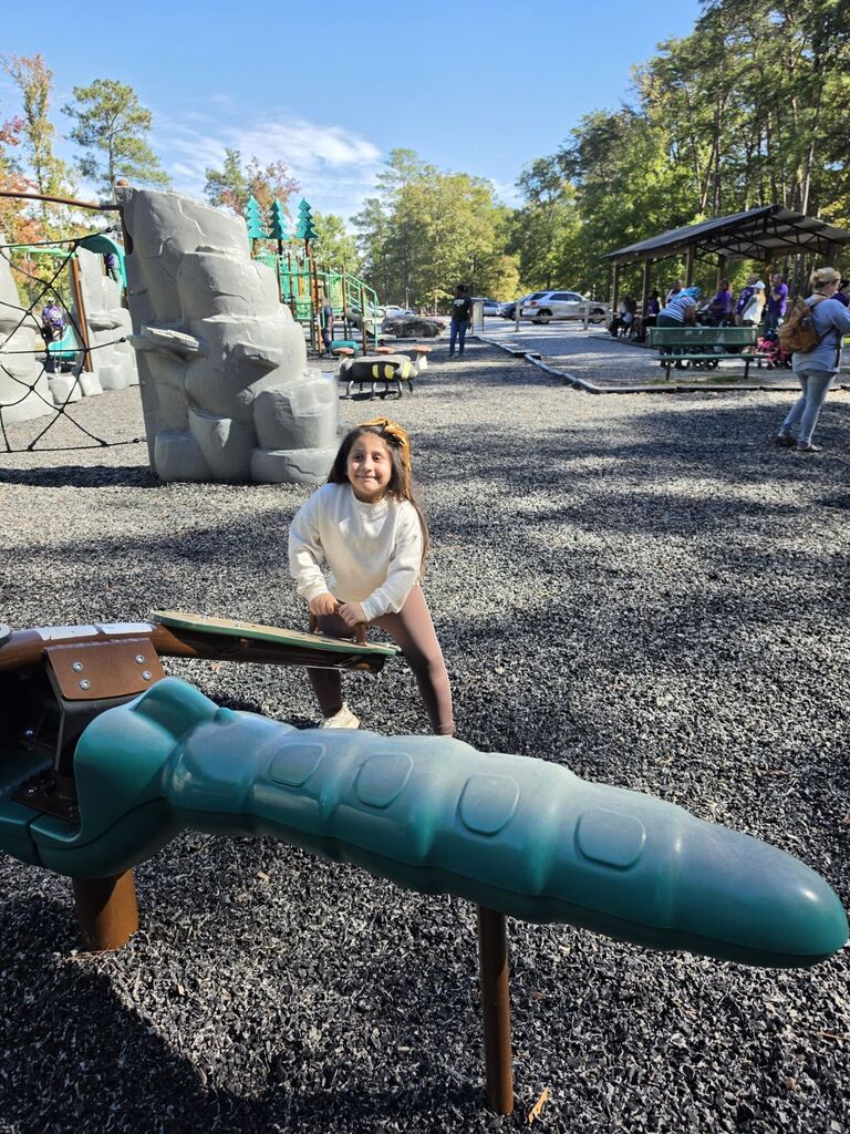 a student riding on a seesaw at the park