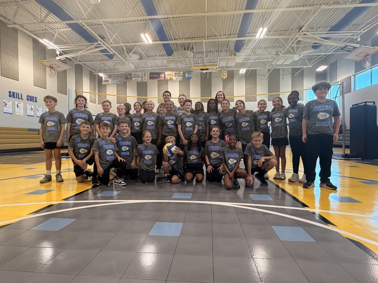 boys and girls newcomb teams with coaches posing in front of the newcomb net 