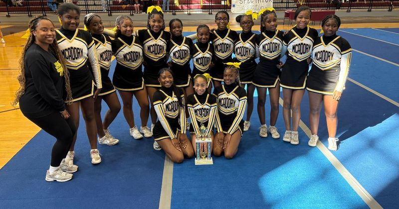 McAdory Middle School cheerleaders pose with a trophy.