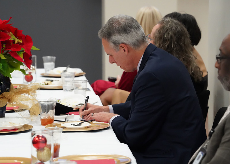 A man takes notes during a meeting. 