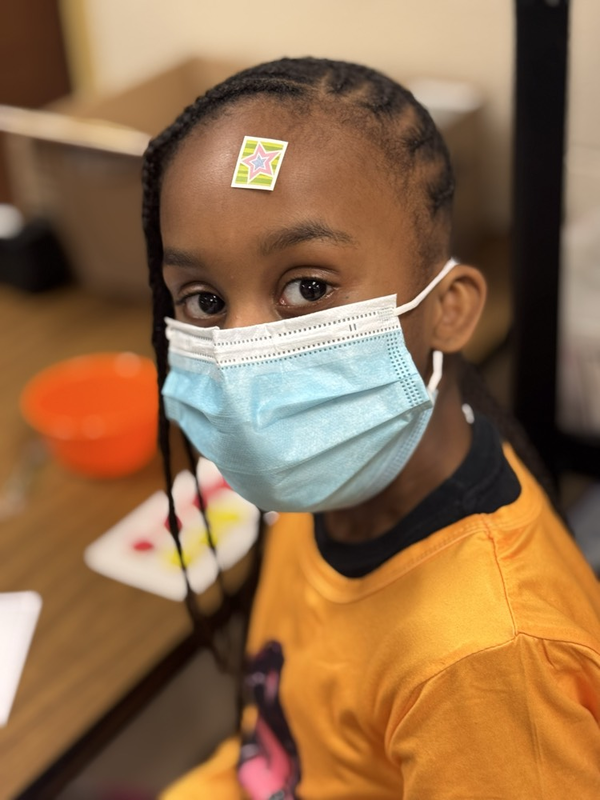 student with sticker on forehead 