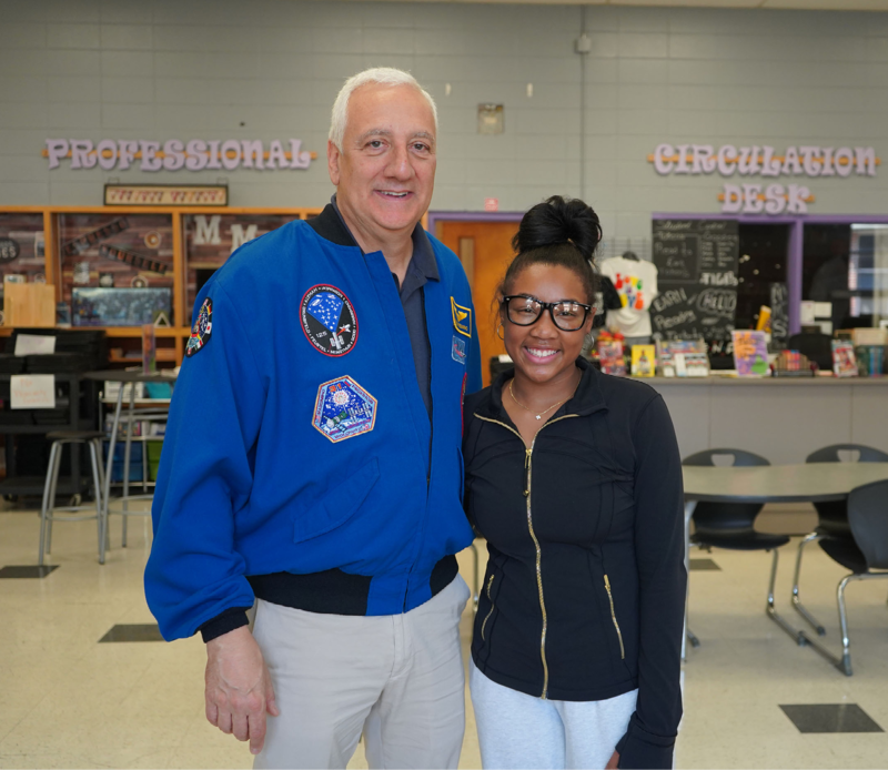 Former NASA Astronaut Mike Massimino stands for a photo with Minor Middle School student Skhyler Cannon in the school library.