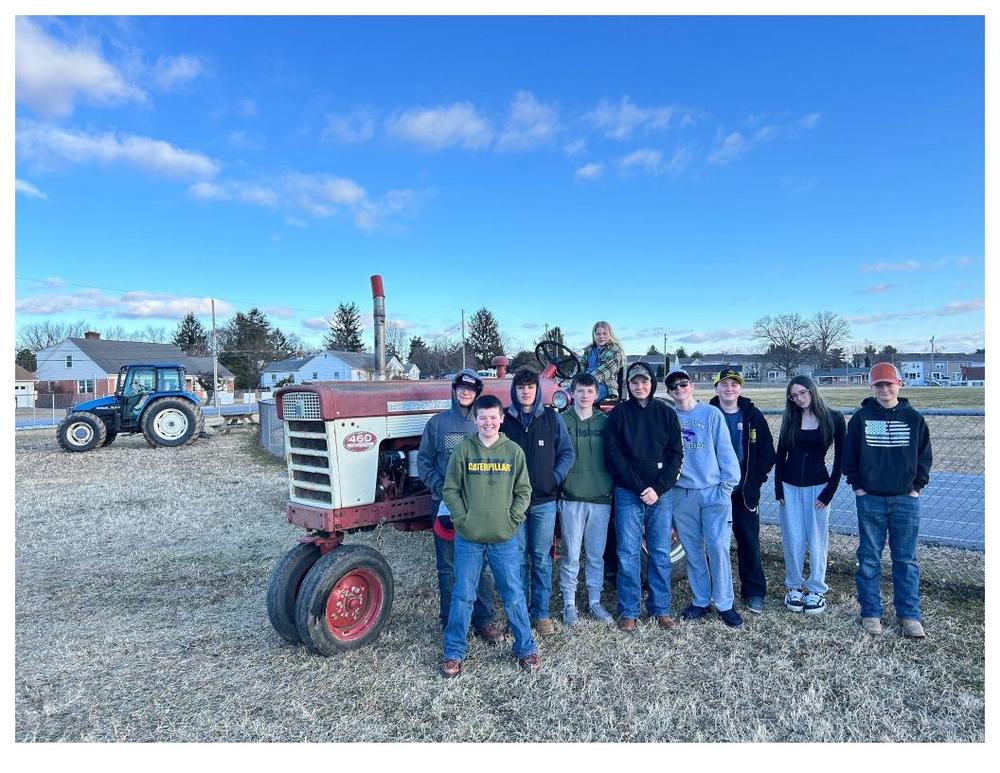 FFA Students posing in front of tractor