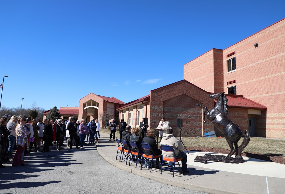 A crowd gathers in front of wMS and the Mustang statue to remember Jodi Brock as Principal Jennifer Moss speaks