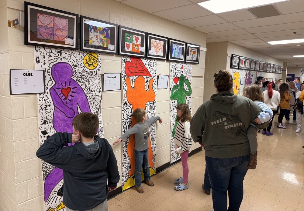 families enjoying artwork in the halls of SJES