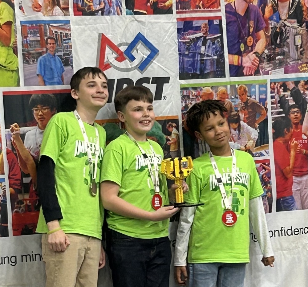 students posing for award holding gold trophy