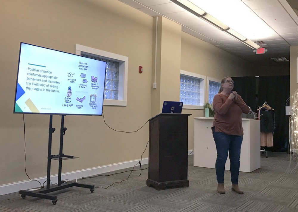 Speaker at PERC coffee chat in front of PowerPoint presentation