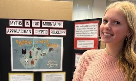 Student with their Social Studies project on Cryptids