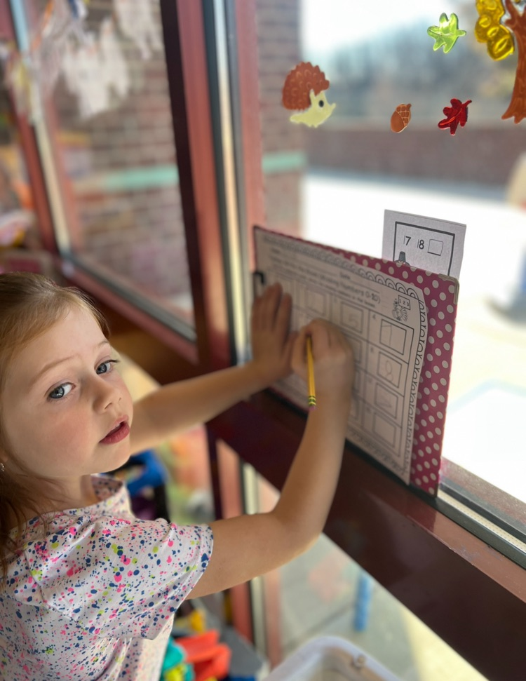 little girl doing a write the room 