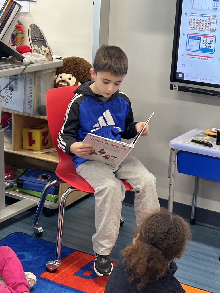 Student reading a book to class