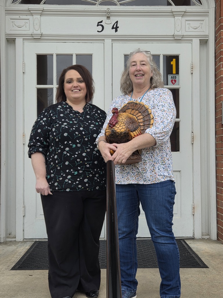 Sheri and Karen holding a turkey  standing in front of Shepherdstown Middle School