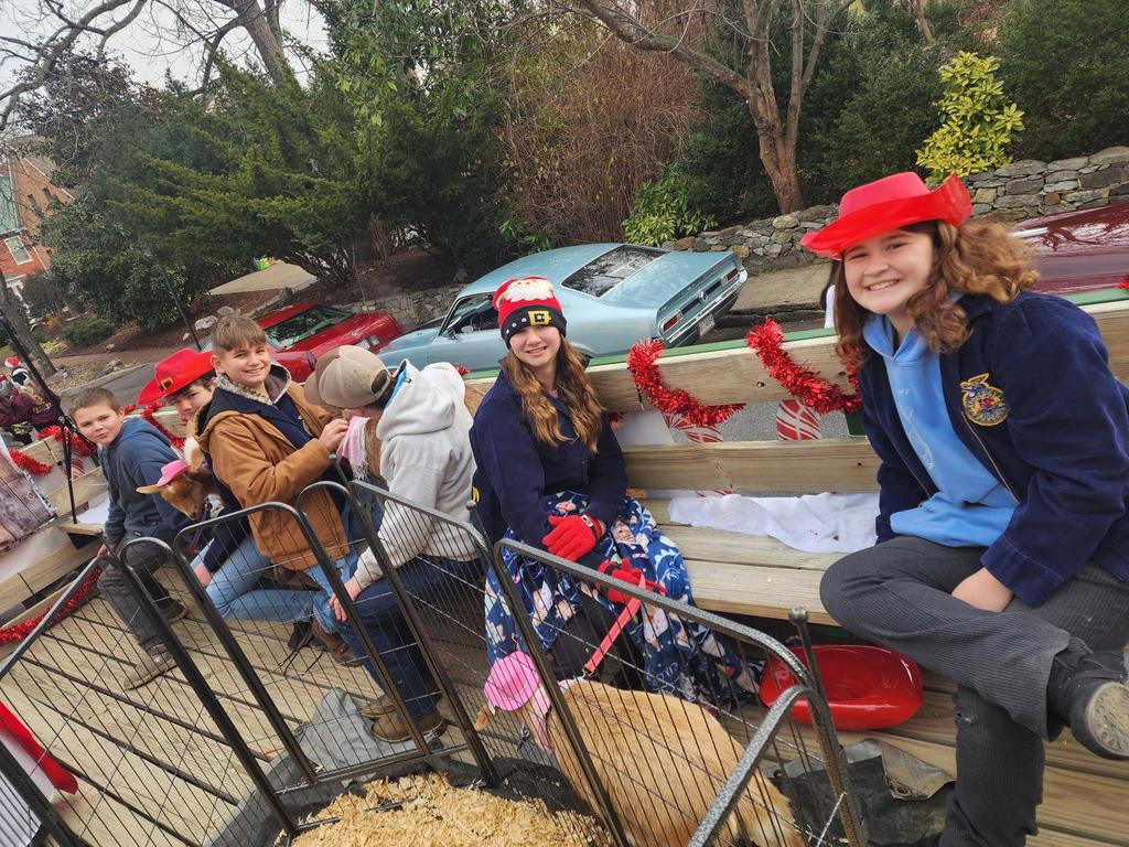 Students pet the goats while waiting for the parade to begin.