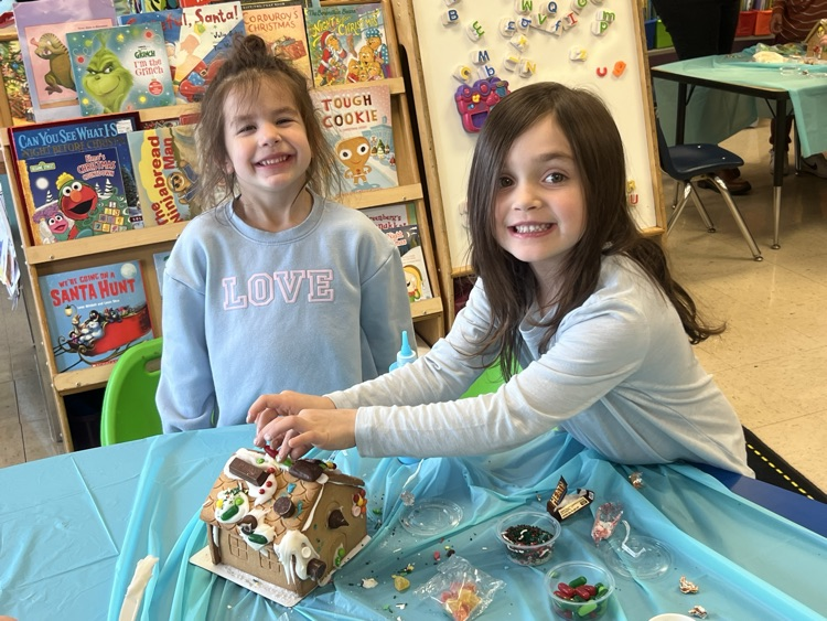 girls decorating gingerbread house 
