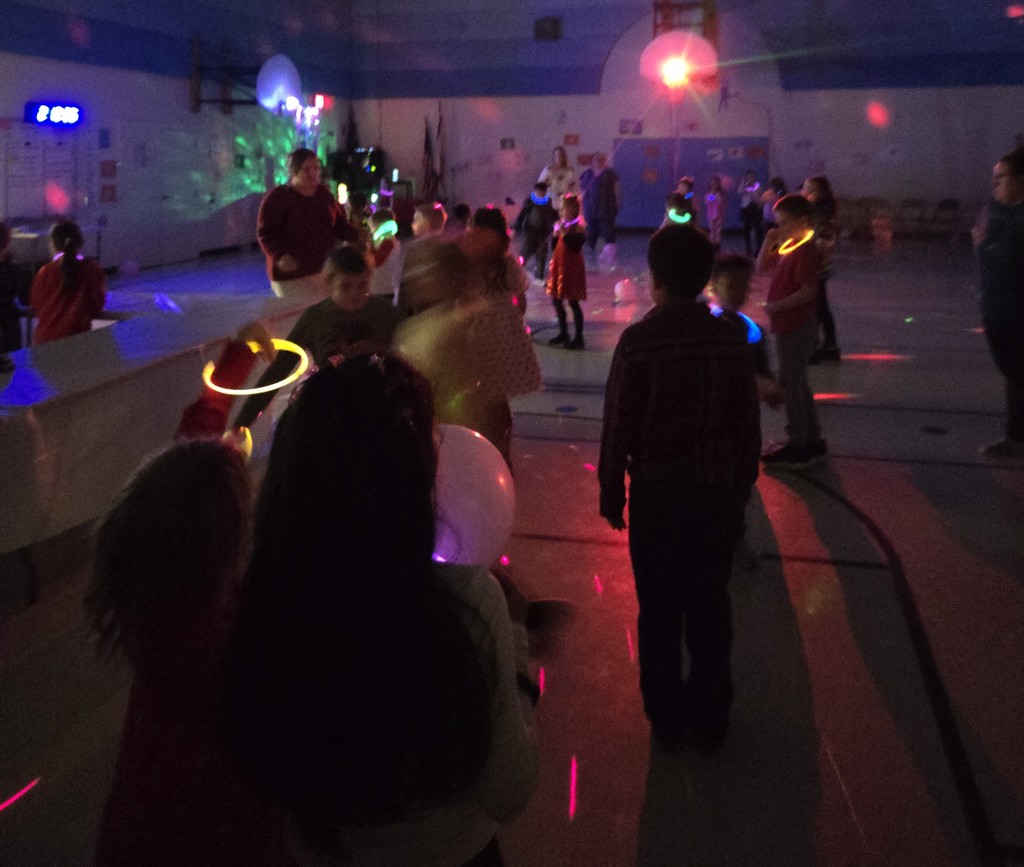 Students with glow sticks in the gym for a dance