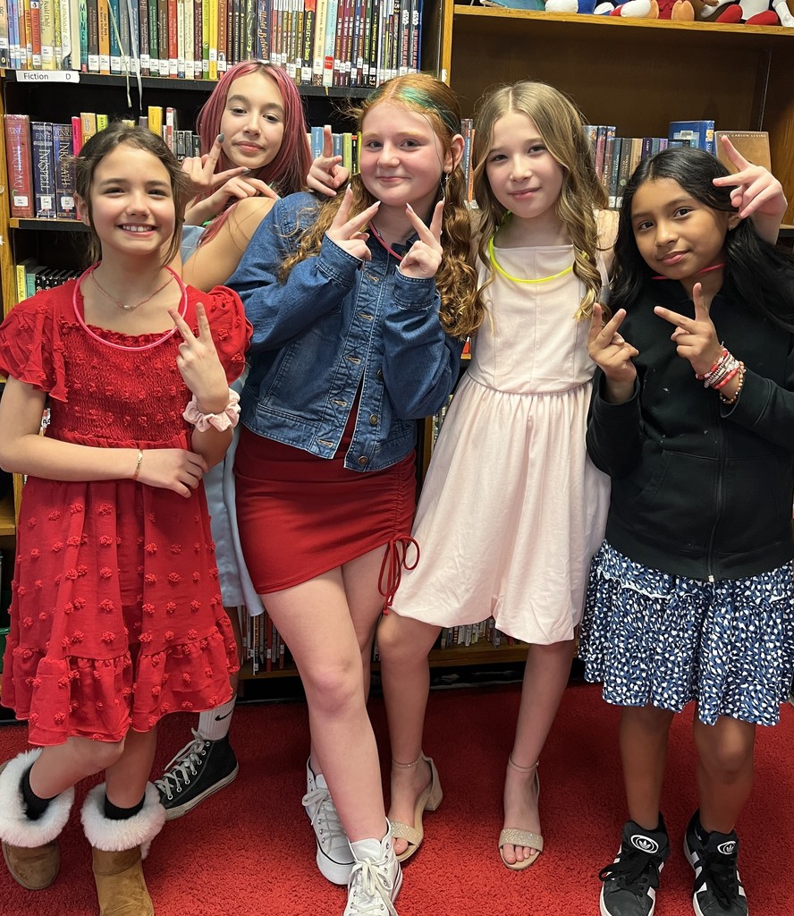 five students in the library dressed for the friendship dance
