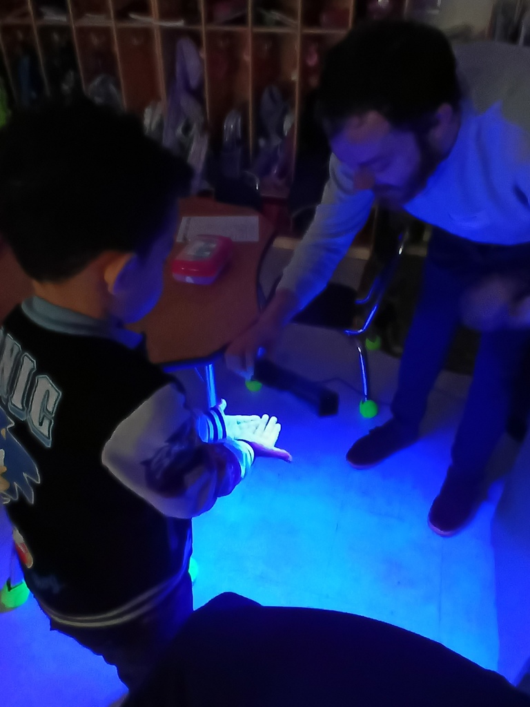 students hands under UVA lamp