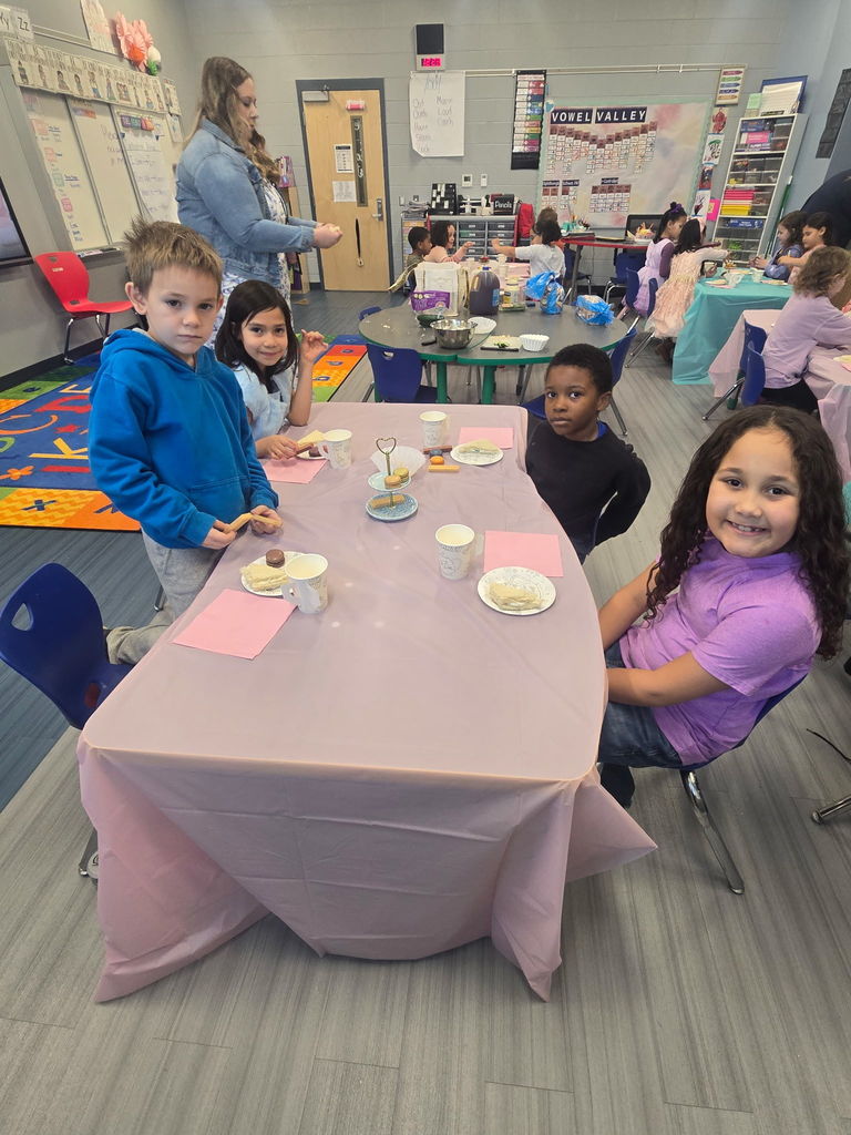 First grade students smiling around a table with their desserts
