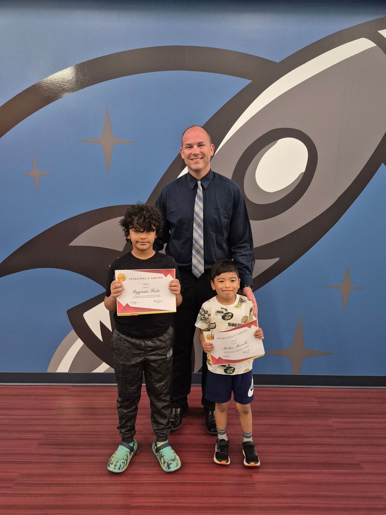 Two students posing with Mr. Astorino with their certificates