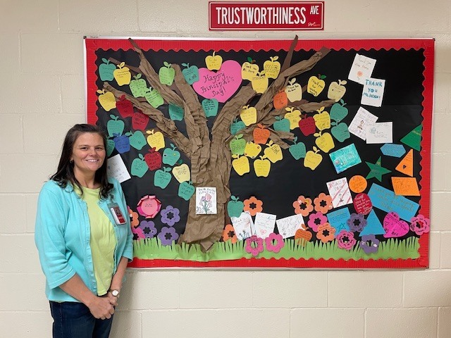 Principal standing in front of a bulletin board of Thank You notes.