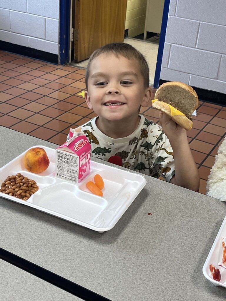 Kindergartener enjoying a cheeseburger.