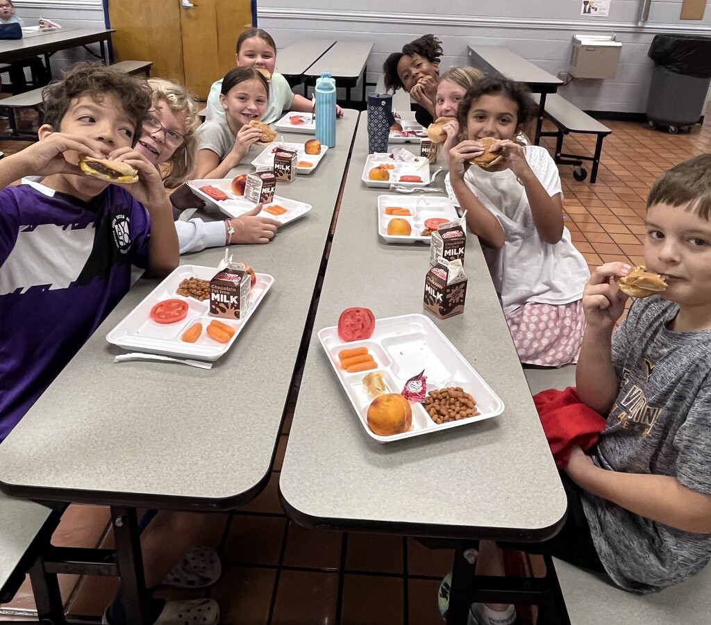 Fourth graders eating cheeseburgers