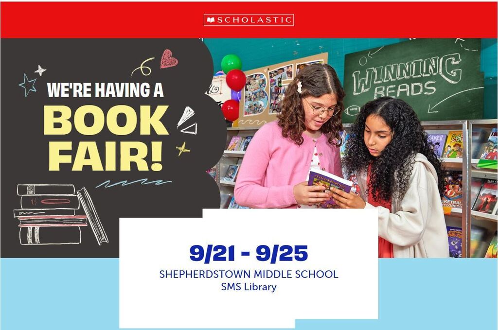 Students looking at a book at the school book fair