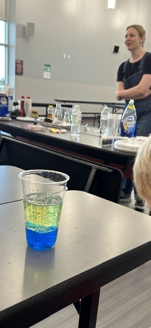 Student with liquid experiment on table