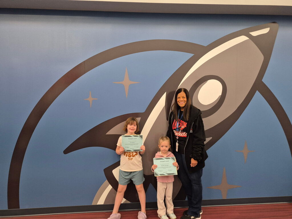 Students posing with Mrs. Terry with their Principal Award certificates