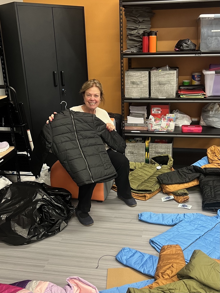 Volunteer Joan holding a donated coat