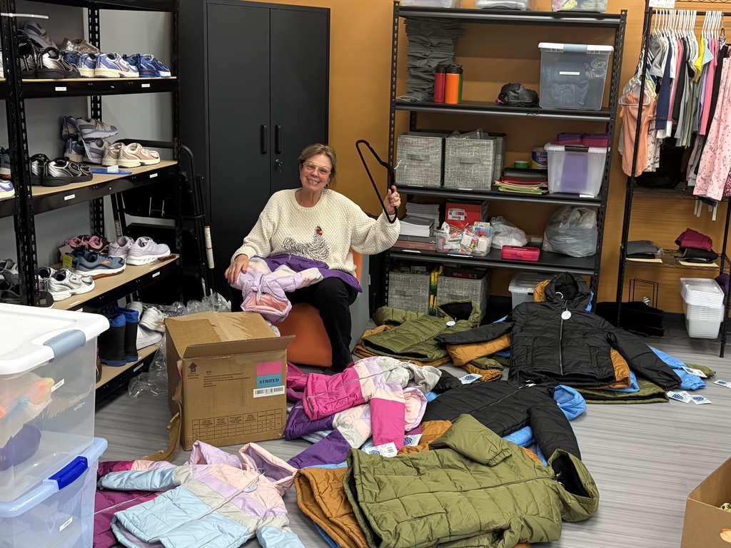 Volunteer Joan sorting and hanging the coats