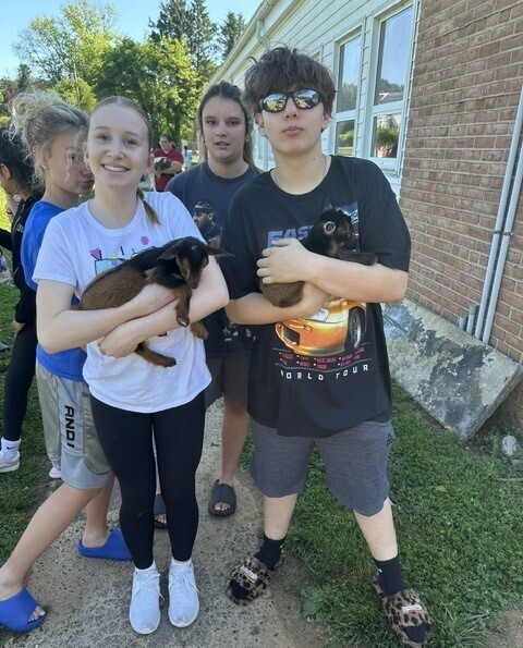 Students holding baby goats