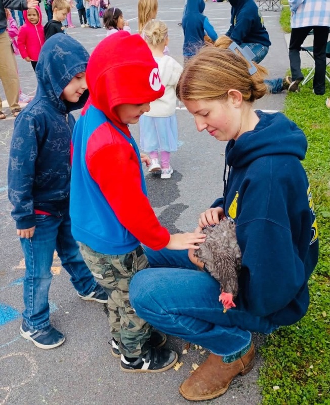 student petting a chicken