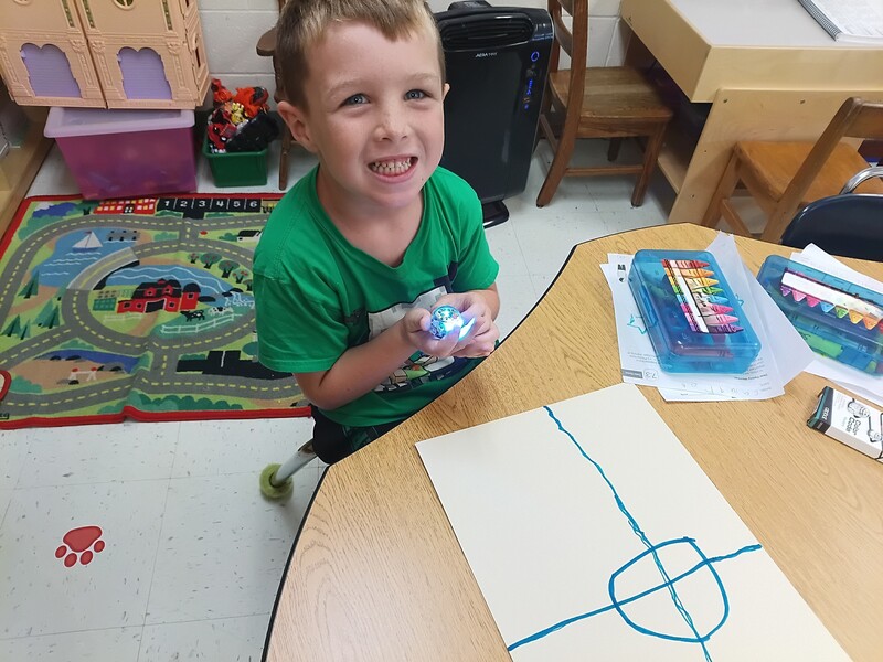 students using Ozobots to practice lines and circles
