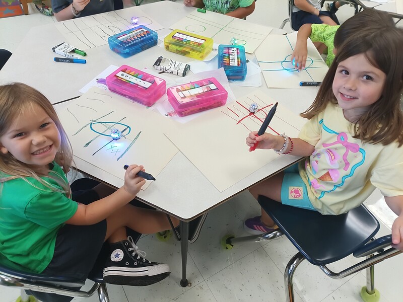 students using Ozobots to practice lines and circles